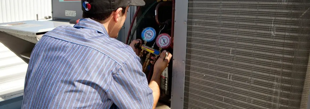 HVAC technician servicing a condenser unit in Imperial Beach
